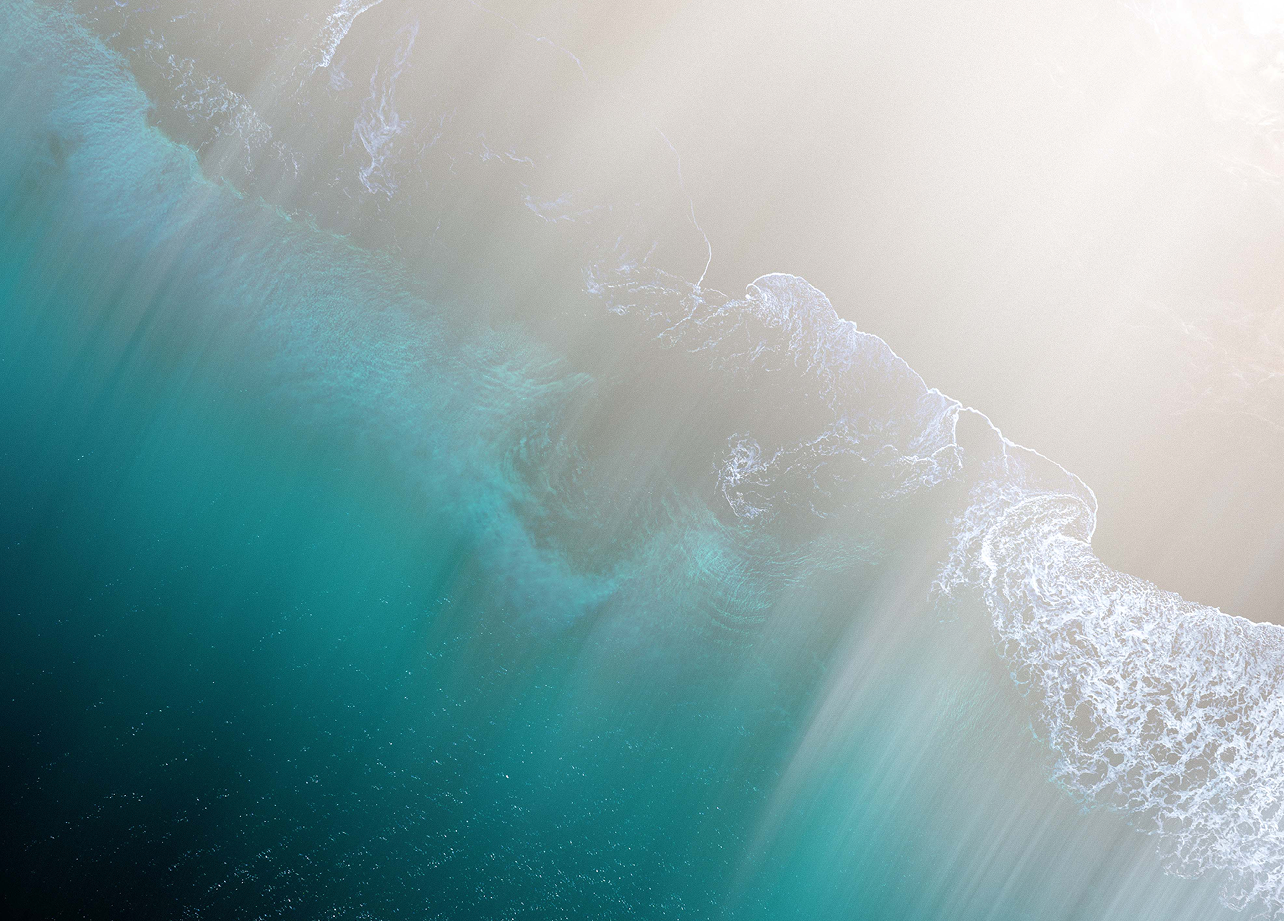 Aerial view of an ocean wave breaking near the shore